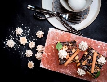 Brownie with coffee meringe on hot pink salt block