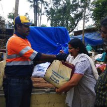 A woman receives Ambuja Cements flood relief material