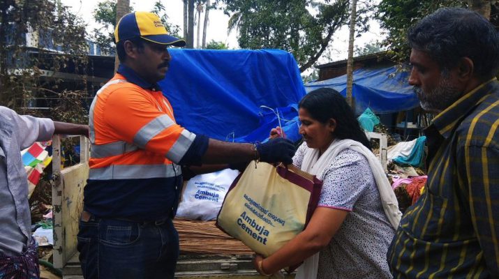 A woman receives Ambuja Cements flood relief material